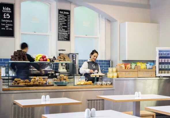 A photo of people restocking the cake stand preparing hot drinks