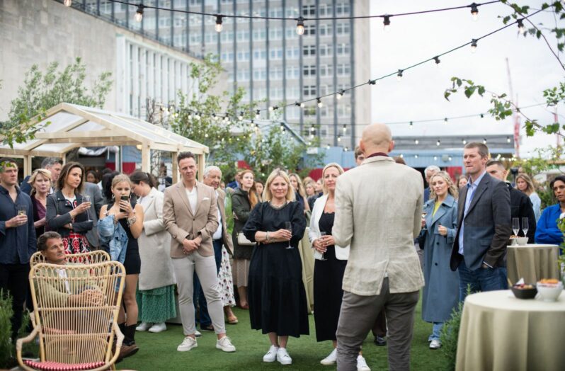 Man giving speech at a networking standing reception event on a rooftop