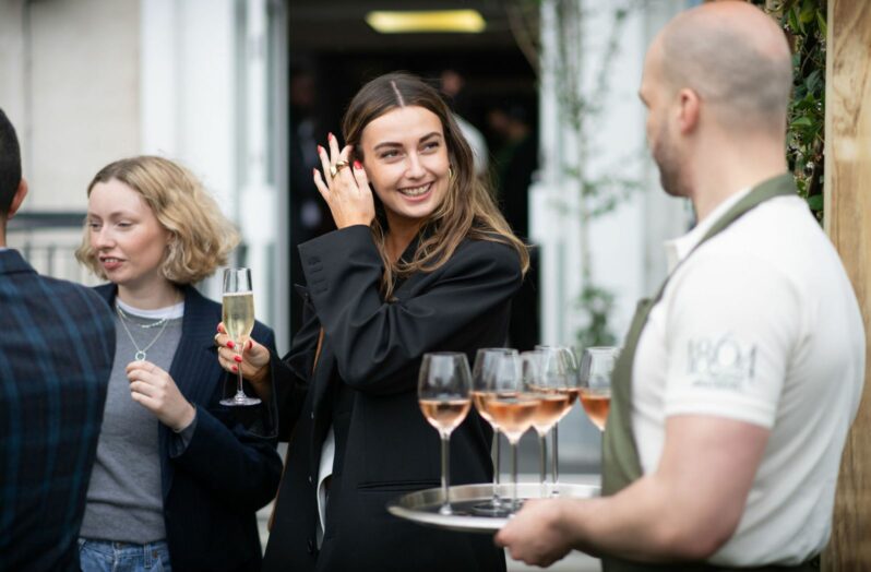 person smiling at a waiter holding drinks